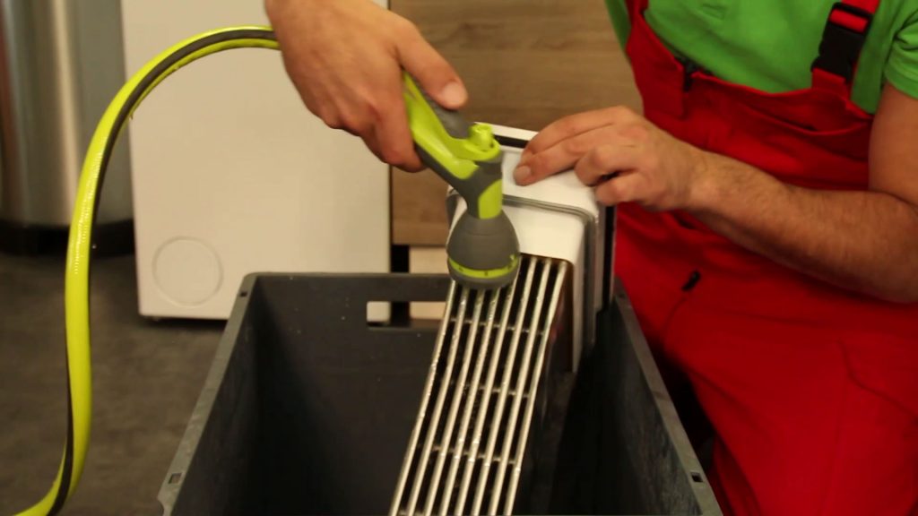 Nettoyage à la douchette du condenseur de sèche-linge