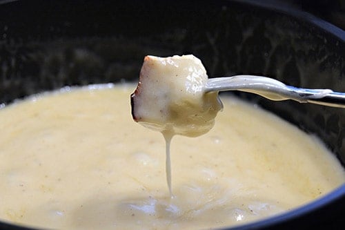 Morceau de pain dans fondue au fromage