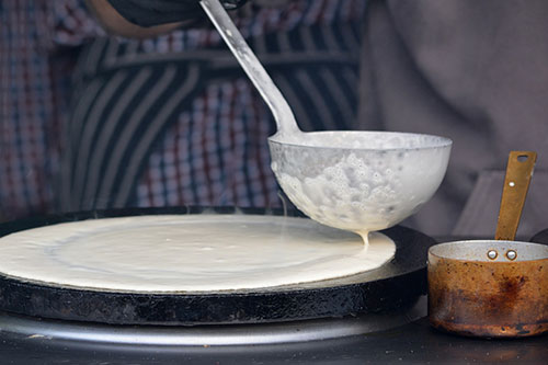 Confection d'une crêpe à l'aide d'une crêpière électrique