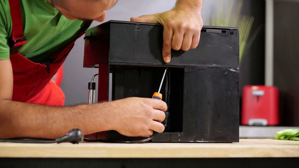 Enlever les vis à l’arrière de la machine à expresso