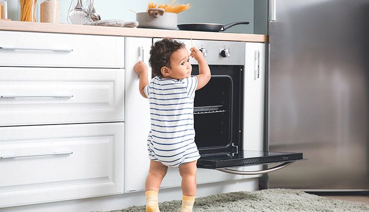 Un jeune enfant joue avec un four électrique