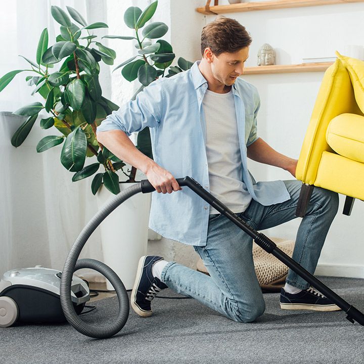 Passer l'aspirateur sous le canapé du salon