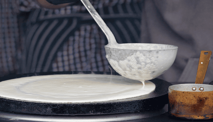 crepiere-louche Verser la pâte à crêpe à l'aide d'une louche sur une crêpière électrique